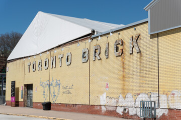 Obraz premium building side featuring white brick relief sign on a yellow brick wall located at 550 Bayview Avenue (Evergreen Brick Works) in Toronto, Canada