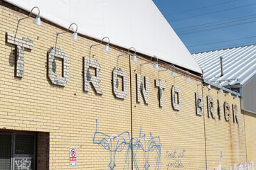 Obraz premium Toronto Brick white brick relief sign on a yellow brick wall located at 550 Bayview Avenue (Evergreen Brick Works) in Toronto, Canada