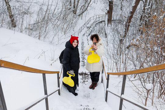 The girls are standing on the stairs. 