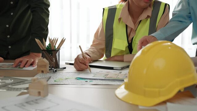 Professional engineer measuring the blueprint. Professional engineer working architectural project at studio on a table with yellow helmet and architectural equipment scatter around. Delineation.