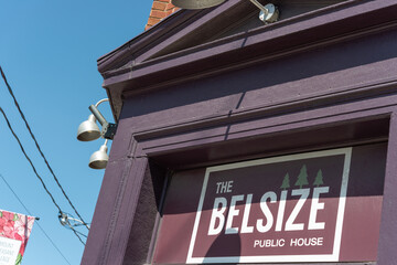 Fototapeta premium close-up of sign and exterior of The Belsize Public House, a restaurant, located at 535 Mount Pleasant Road in Toronto, Canada