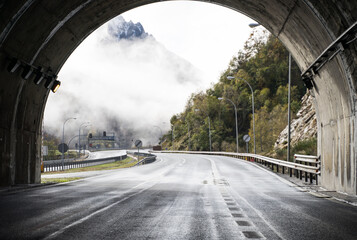 Misty mountain road emerging from tunnel in Asturias
