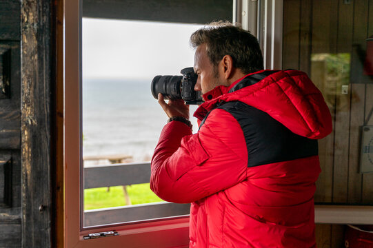 Photographer takes photos from cozy cabin interior
