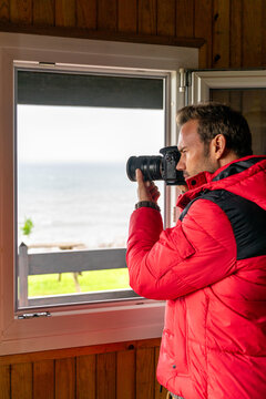 Photographer capturing seascape from a cozy interior