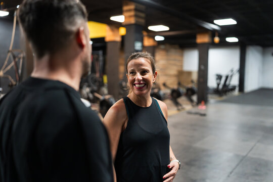 Smiling pregnant woman talking to her trainer in the gym