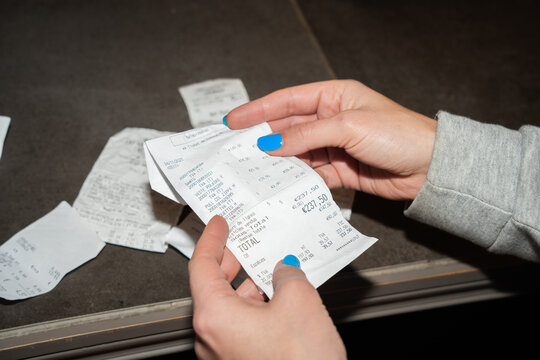 Female Hands Holding A Business Receipt.