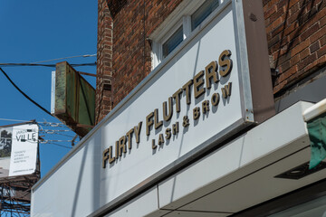 Fototapeta premium exterior light box sign of Flirty Flutters Lash & Brow, a beauty salon, located at 691 Mount Pleasant Road in Toronto, Canada