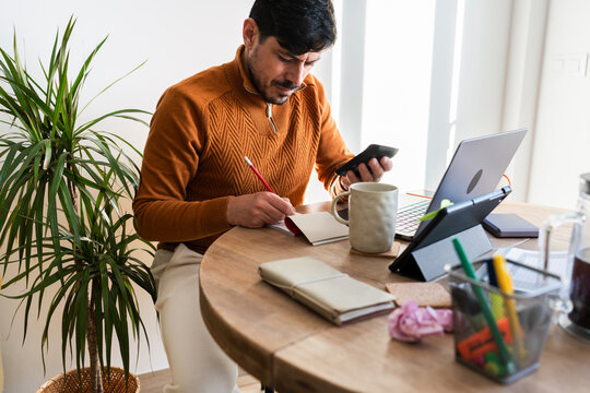 Man using a calculator at home to review household finances.