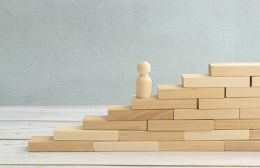 wooden figurine of a man on top of wooden cubes.