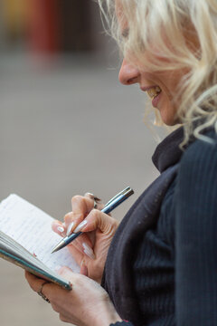 Smiling stylish woman writing on a notebook 