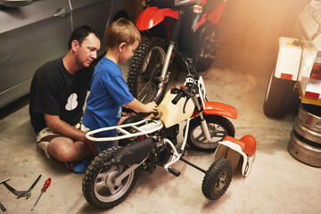 Parent, child and fixing bike in garage at home for teamwork, support and repair with tools. Family...