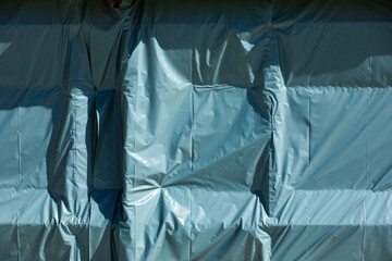 Background texture of plastic covering shaped by wind