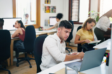Fototapeta premium Designer, laptop and planning with office, writing notes and teamwork for small business startup. Team, diversity and brainstorming with creative, workplace or coworking for online design agency