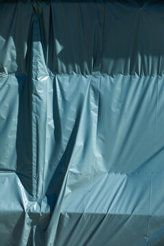 Background texture of plastic covering shaped by wind