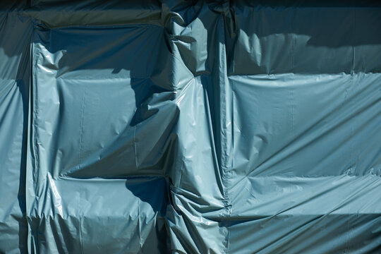 Background texture of plastic covering shaped by wind