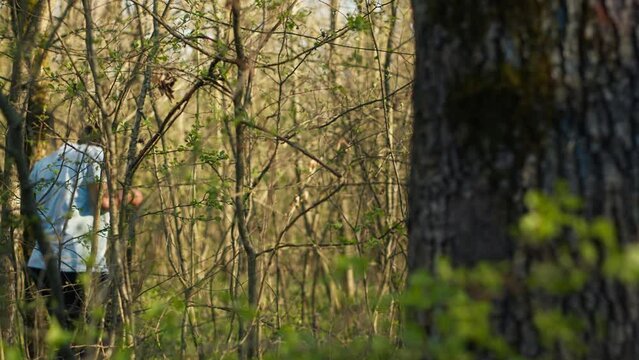 Civilian search party beginning the manhunt within the forest area, screaming the missing person name and tracking his steps. Rescuers group looking for clues, emergency mission. Camera A.