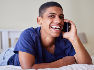 Young man, happy conversation and phone call in bedroom, share funny story and laughing with...