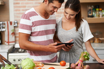 Cooking, tablet and couple learning in kitchen for healthy food or vegetables for lunch or dinner....