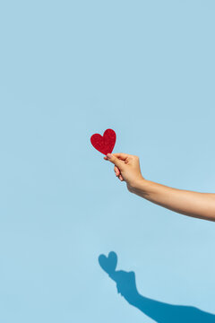 vertical photo of a Hand Holding Red Glitter Heart
