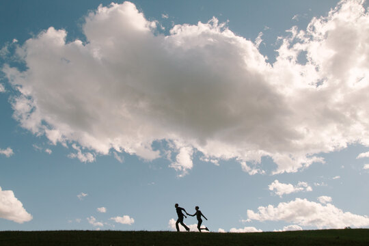 Silhouette of Couple in Love Holding Hands and Having Fun in Nature