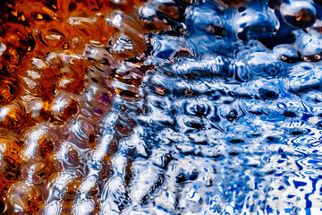 The texture of liquid metal with the reflection of multicolored light