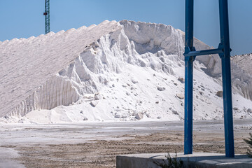 Vast mounds of salt dominate the scene, with industrial frames hinting at the scale of this mining...