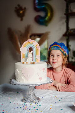 Girl turning five with her unicorn and pastel rainbow themes bday cake