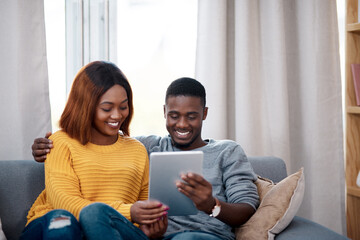 Black couple, tablet and couch with digital app in home for streaming entertainment, movie or...