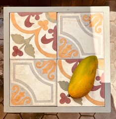 mango on a background of bright tiles - travel texture in Cambodia