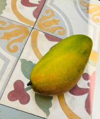 mango on a background of bright tiles - travel texture in Cambodia