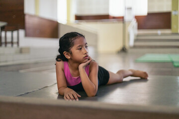 Young gymnast girl looking bored during the training