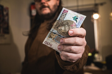Close up on a mans hand holding polish zloty banknotes economic situation income in poland