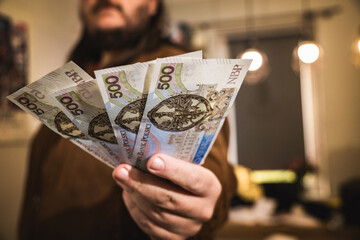 Close up on a mans hand holding polish zloty banknotes economic situation income in poland