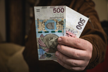 Close up on a mans hand holding polish zloty banknotes economic situation income in poland