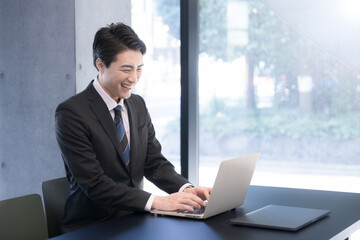Smiling profile of a handsome businessman using a computer