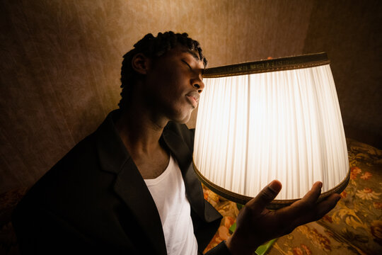A man examines a switched-on lamp