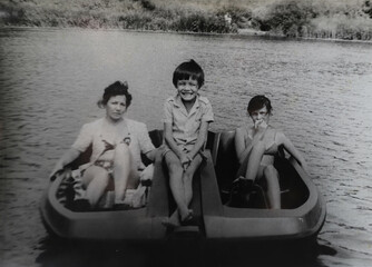 mother with her son and daughter are sitting on a boat