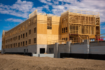 Large wood frame and concrete multi story apartment complex under construction.