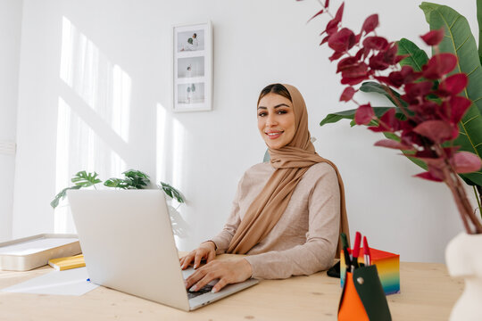 Possible woman in hijab using computer in workplace