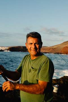 Portrait a smiling male holding a fishing rod