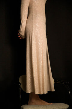 Elegant woman posing in evening dress against a dark background
