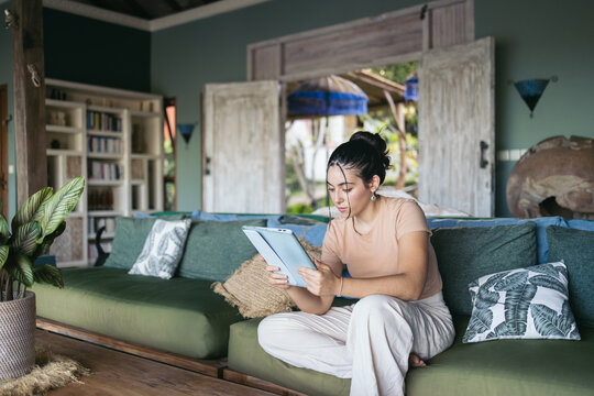 Woman reading e-books on tablet at home