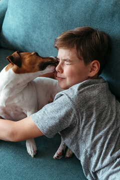 Young boy with favorite dog resting at home. 
