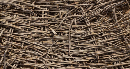 Weaving of twigs of branches. A man-made background smoldering on the ground.