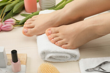 Woman with neat toenails after pedicure procedure on white wooden floor, closeup