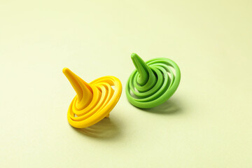 Two colorful spinning tops on green background, closeup