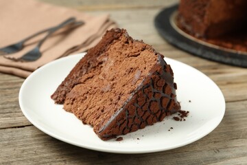 Piece of delicious chocolate truffle cake on wooden table, closeup