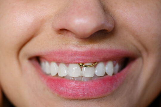 Crop of woman's mouth with frenum pierced
