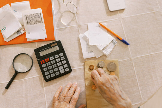 Senior man counting the money and making calculation 