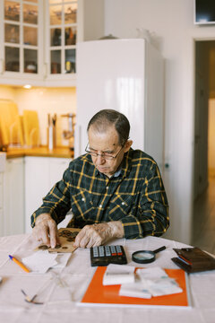 Senior man counting the money and making calculation 